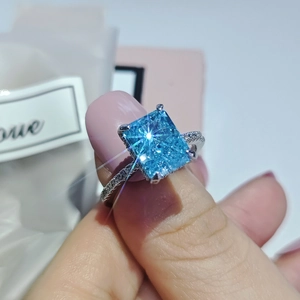 Elegante anillo con zafiro azul cuadrado y piedras pavé en montura de plata