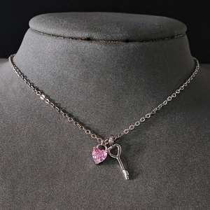 Collar con colgante de candado de corazón rosa y llave en una cadena de plata minimalista