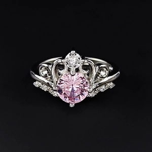 Macro shot of vintage crown ring with pink center stone and ornate silver detailing