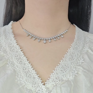 Elegant silver tassel necklace with sparkling teardrop zircons on a white lace V-neck top