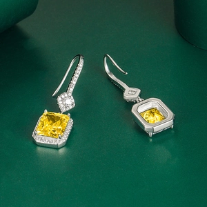 Orecchini pendenti in argento con zircone giallo quadrato e diamanti pavé su pelle scura