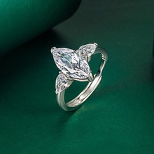Macro shot of a marquise-cut crystal ring with pear side stones on dark green leather