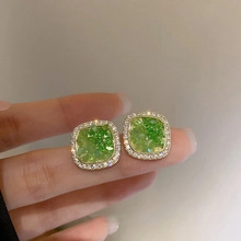Macro di orecchini vintage dorati con cristallo verde e alone di zirconi