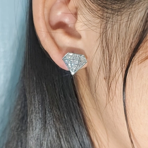 Ohrstecker in Diamantform mit Zirkonia-Mikropavé am Ohr des Modells getragen