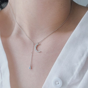 Elegant silver moon and blue star necklace with crystals worn on neck for women
