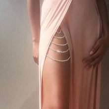 Macro detail of a four-layer silver thigh chain with sparkling rhinestones on a leg