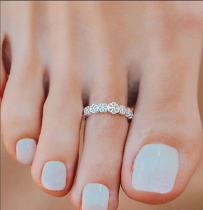 Detailed view of silver hollow flower toe ring featuring five-petal floral patterns