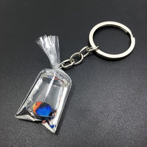 Macro detail of goldfish in transparent water bag pendant with silver key ring