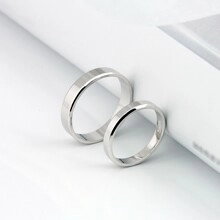Détail macro de bagues de couple minimalistes en acier titane poli avec texture losange