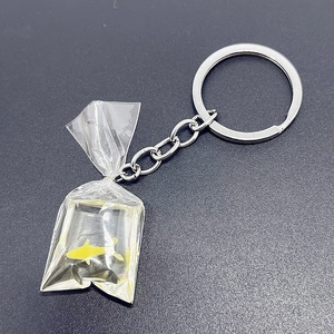 Macro view of a creative fish bag keychain with yellow goldfish in transparent liquid pouch