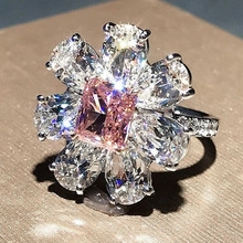 Macro shot of silver ring featuring a square pink zircon center with floral zircon petals