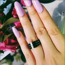 Dettaglio anello a treccia nero con strisce d'argento indossato su un dito