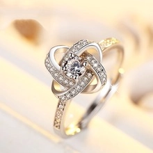 Macro view of a four-prong zircon ring with sparkling stones and polished silver finish