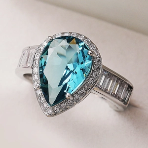 Pear cut sea blue teardrop engagement ring in polished silver with halo diamonds