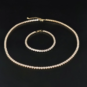 Dettaglio di set collana e bracciale tennis dorati con zirconi quadrati su nero
