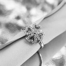 Primer plano detallado de un anillo de trébol plateado con circonitas cúbicas en pavé