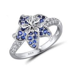 Primer plano del anillo de plata 925 que muestra el diseño floral y las circonitas azules
