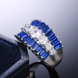 Luxury silver ring featuring five white zircons and rows of deep blue side stones