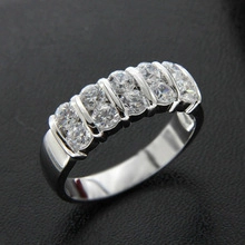 Close-up of double-row silver cubic zirconia ring on a dark textured background