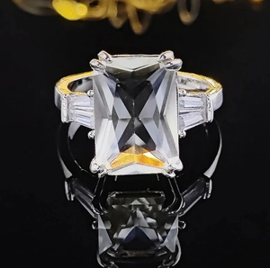 Luxuriöser Zirkonia-Ring im Smaragdschliff mit Goldakzenten auf Spiegelbasis