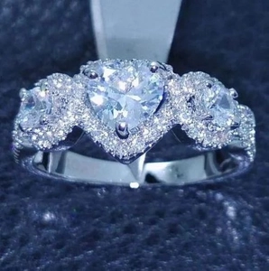 Elegante anillo de corazón plateado con cristales halo y banda de circonitas engastadas