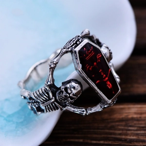 Vintage gothic vampire bat skull ring with coffin red stone on a wooden table