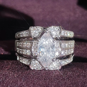 Three-piece bridal ring set with marquise cut center stone and petal design accents