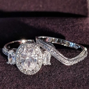 Elegante juego de anillos de boda de plata con circonita ovalada en caja de terciopelo