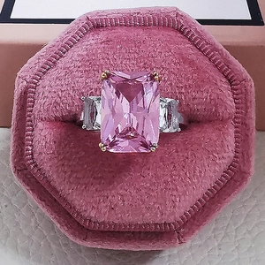 Macro detail of radiant pink crystal ring with white zircon in a luxury velvet box