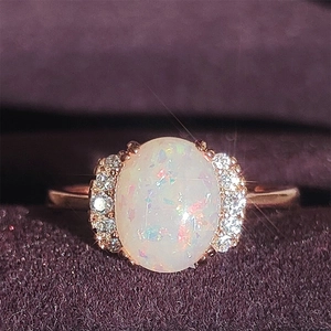 Eleganter roségoldener Ring mit großem ovalem weißem Opal und feinen Pavé-Akzenten