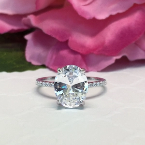Elegant silver ring with oval cut zircon and pavé setting on a romantic floral background