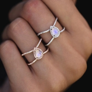 Dettaglio degli anelli con pietra di luna a goccia in argento e oro rosa con diamanti