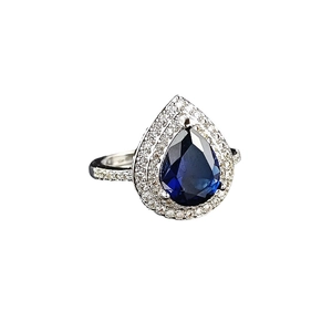 Pear cut blue topaz halo ring with double rows of diamonds in a white gold finish