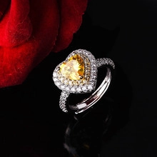 Macro-opname van hartvormige ring met gele steen, kristallen halo en verstelbare band