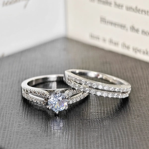 Macro detail of silver ring set featuring a 6-prong round zircon and micro-pave wedding band
