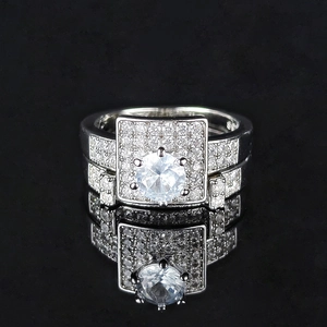 Macro view of women's stacked ring set with square halo and shimmering round center stone