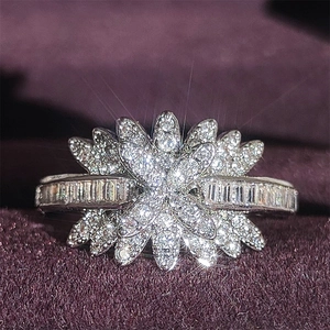 Macro d'une bague argentée avec pétales de fleurs sertis de zircons cubiques brillants