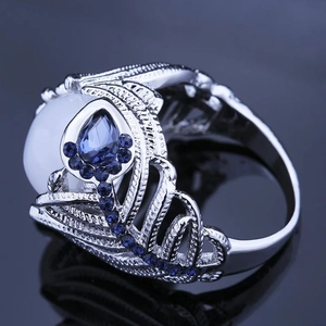 Anillo retro de plata con piedra de luna y circón azul con diseño floral calado
