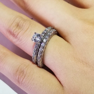 Detailed view of women's bridal ring set with six-prong solitaire and pave wedding bands