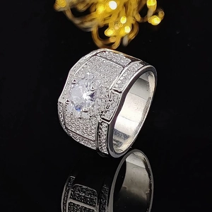 Dettaglio macro di anello da uomo con diamante centrale e pavé di zirconi lucidi
