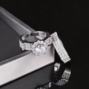 Macro view of a round halo engagement ring set with micro-pave crystals on a black base
