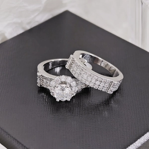 Close-up of a silver-tone bridal ring set with sparkling zircon stones on a black box.