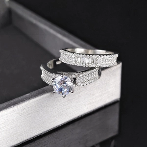 Detailed top view of silver couple ring set with round cut center stone and pavé diamonds