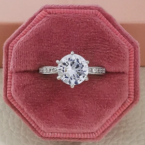 Elegante anello solitario a sei griffe con pietre laterali in scatola di velluto rosa