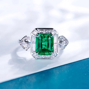 Elegant emerald cut green gemstone ring with silver halo and pavé diamond band