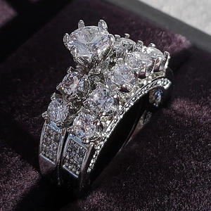 Macro view of wedding ring set with round cut diamonds in purple velvet box