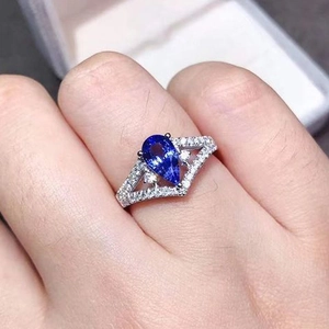 Pear-cut sapphire ring with V-shaped double-layer silver band worn on finger