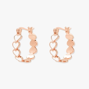 Vue détaillée des créoles coeur en or rose avec des motifs ajourés sophistiqués