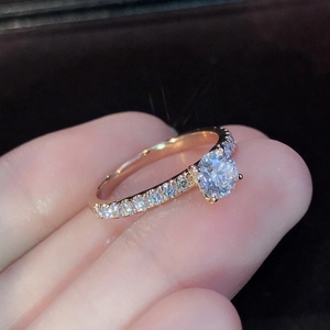 Elegante anillo de compromiso en oro rosa de 18K con solitario redondo y pavé de diamantes