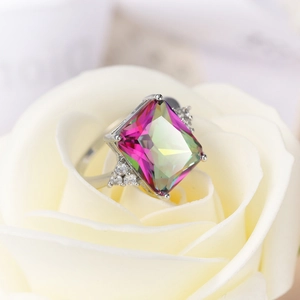 Regenbogen-Zirkonia-Ring mit quadratischem Edelstein auf einer weißen Rose